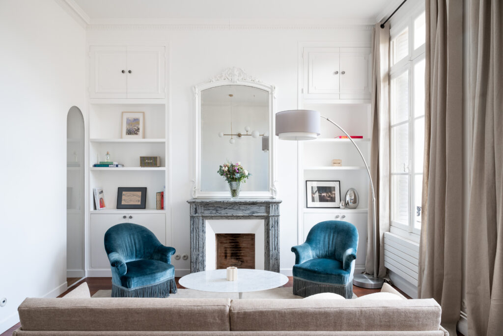 Vue du salon avec fauteuils crapauds et miroir à fronton, pour aménager un bien d'exception.