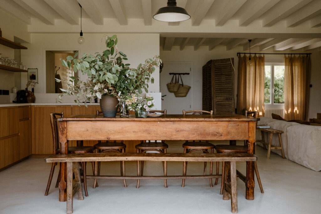 salle-a-manger-dans-une-maison-bretonne-grande-table-en-bois-chinee-avec-bans-et-chaise-liant-la-salle-a-manger-au-salon