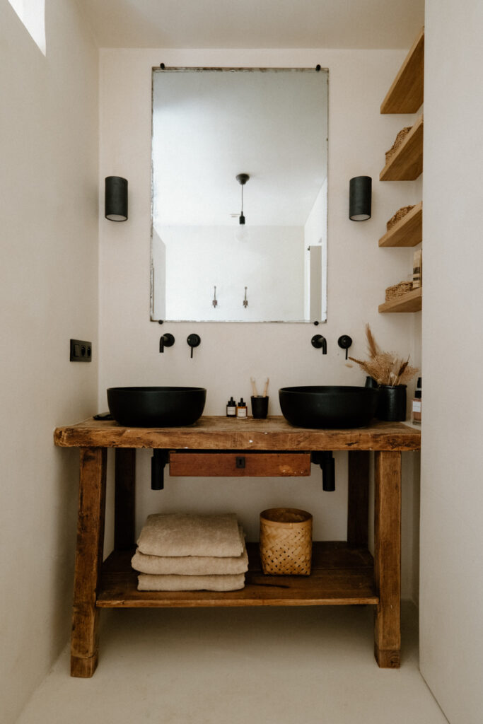salle-de-bain-avec-vasques-noires-sur-un-meuble-en-bois-et-grand-miroir