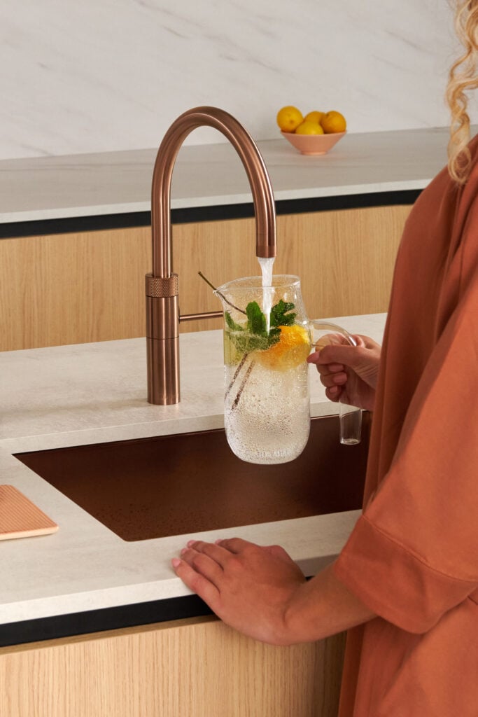 Robinet Quooker en cuivre rosé dans une cuisine contemporaine